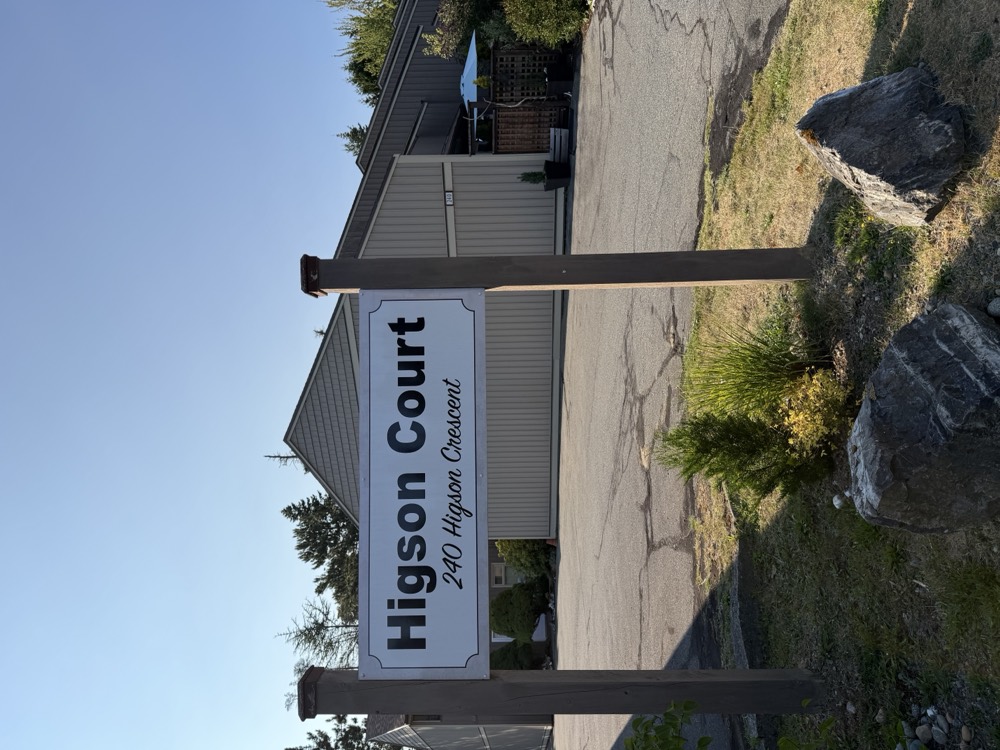 The Higson Court sign at the entrance off the old highway, set in planting.